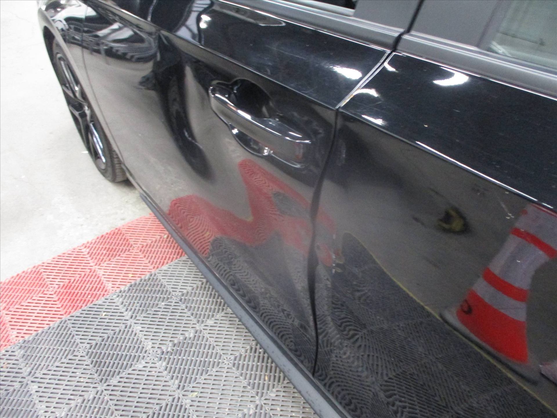 Door crease damage on a black Honda Civic
